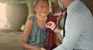 Une infirmière vérifie le pouls d’une femme âgée.